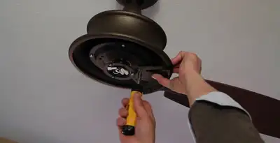Electrician installing ceiling fan mounting bracket and fixture in San Antonio, TX