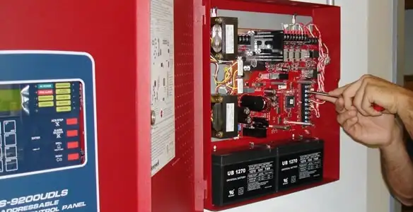 fire alarm installation service showing technician configuring fire alarm control panel in San Antonio, TX
