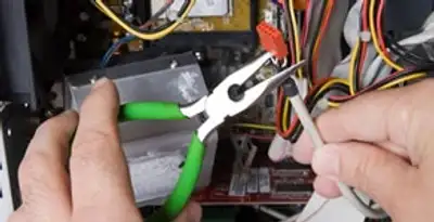 Licensed electrical contractor performing electrical repair with tools in Helotes, TX
