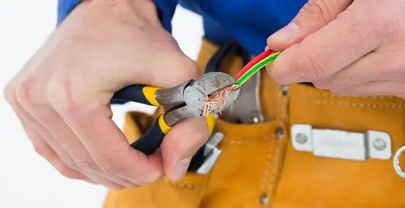 licensed electrician securing electrical wiring with professional tools during service work in San Antonio, TX