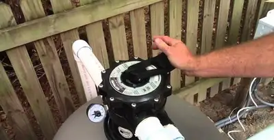 pool pumps service showing professional adjustment of pool pump control system in San Antonio, TX