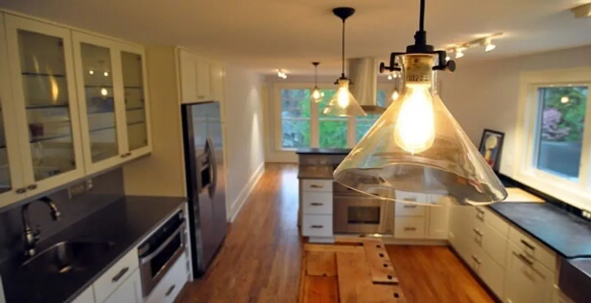 Residential electrician installing modern indoor light fixture in a home in San Antonio, TX
