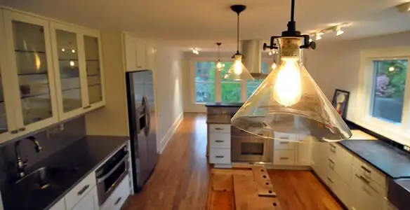 Residential electrician installing modern indoor light fixture in a home in San Antonio, TX