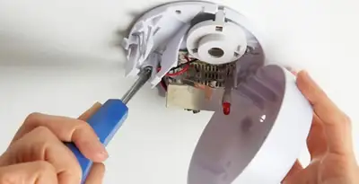 Certified technician wiring smoke detector during installation in San Antonio, TX